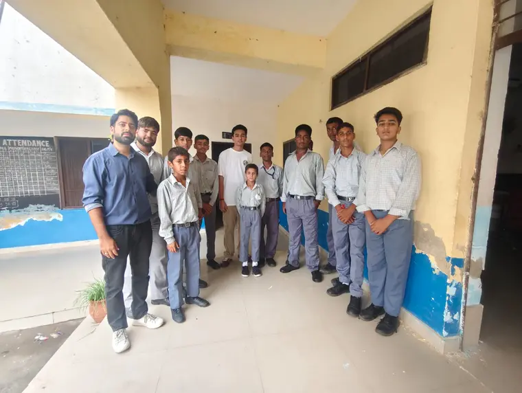 Facilitators and students outside a partner school