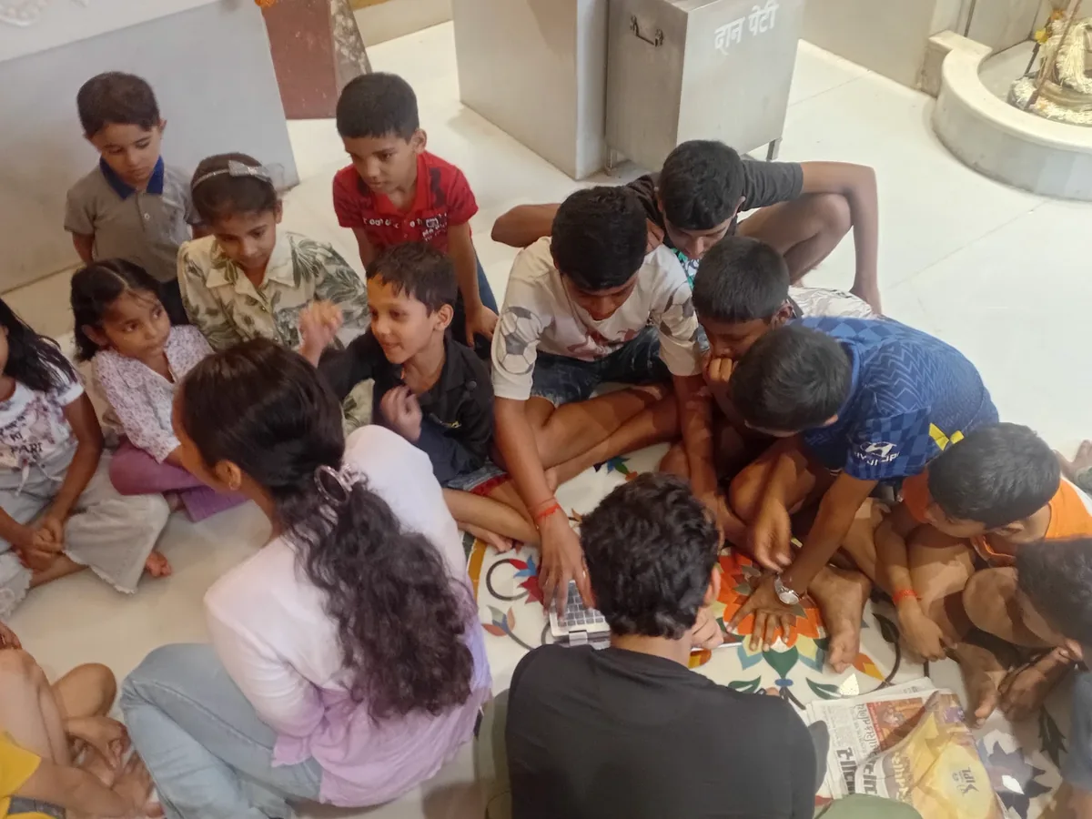 Children gathered around a laptop during an Avana session